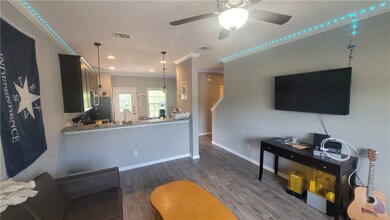 Living area with a ceiling fan, wood finished floo