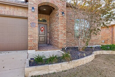 View of exterior entry featuring brick siding and a garage