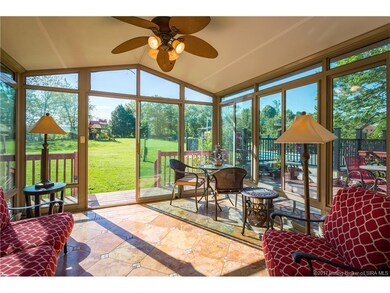 The gorgeous enclosed porch is an inviting place t