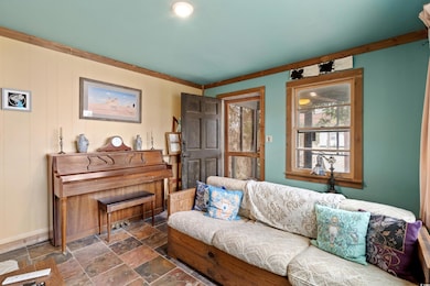 Living area featuring stone tile floors and basebo