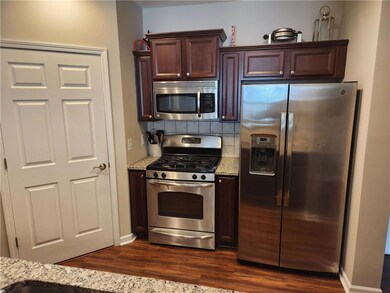 Kitchen featuring dark brown cabinets, appliances 