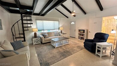 Living room featuring vaulted ceiling with beams,