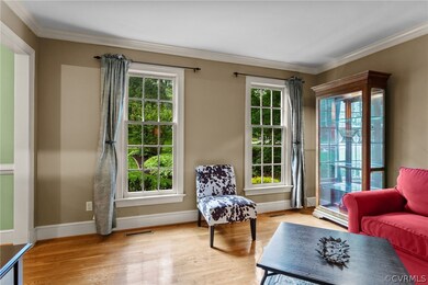 Sitting room with plenty of natural light, ornamental molding, and light wood-type flooring
