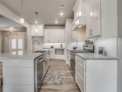 Large kitchen island. Solid hardwood cabinetry and granite countertops with under-cabinet lighting and classy backsplash. American made appliances. And those FRONT DOORS!