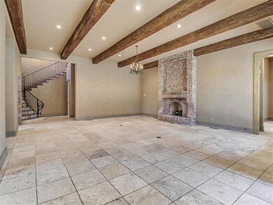 Living room featuring a fireplace, a chandelier, b