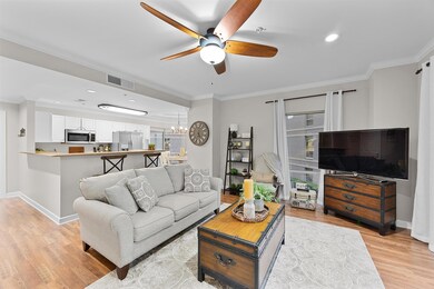 Living area with a ceiling fan, light wood-style floors, crown molding, a chandelier, and recessed lighting