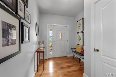 Foyer featuring light wood finished floors and baseboards