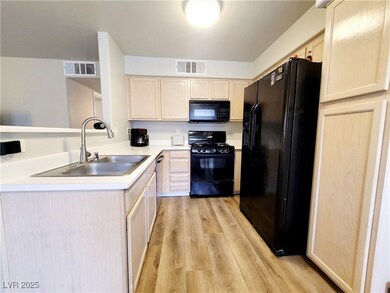 Kitchen with visible vents, a sink, light wood-sty