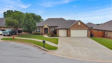 View of front facade featuring a garage, concrete driveway, and brick siding
