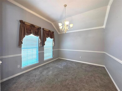 Spare room with ornamental molding, vaulted ceiling, a chandelier, and dark carpet