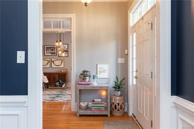 Welcoming foyer with warm hardwoods and transom de