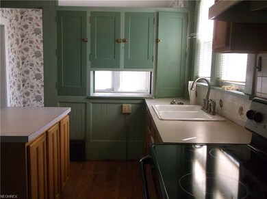 Kitchen has laminate flooring and features a pass 