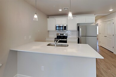 Kitchen with stainless steel appliances, light wood finished floors, tasteful backsplash, hanging light fixtures, and recessed lighting