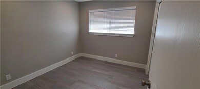 Spare room with baseboards and dark wood-type flo