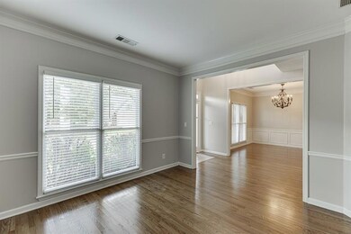 Spare room with crown molding, healthy amount of natural light, a chandelier, and wood finished floors