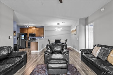 Living room featuring baseboards, wood finished fl