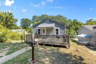 View of front of house featuring a wooden deck and a front yard