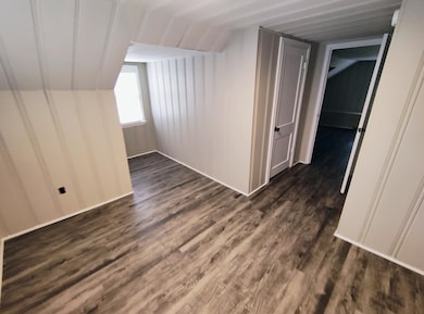 Additional living space featuring dark wood finished floors