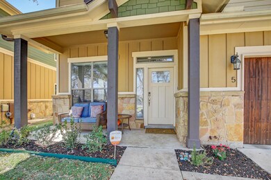 Entrance to property with stone siding, covered p