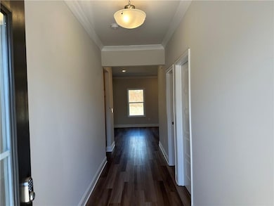 Hall featuring ornamental molding, dark wood-style