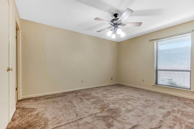 Unfurnished room with baseboards, a ceiling fan, a