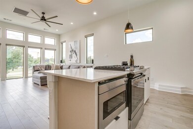 Kitchen with stainless steel appliances, decorative backsplash, a breakfast bar, decorative light fixtures, and large island