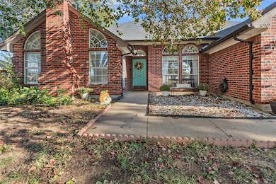 View of front of house featuring brick siding, a chimney, and a shingled roof