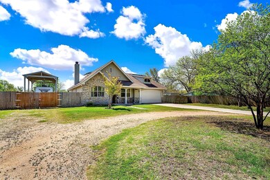 View of front of home with driveway, stone siding