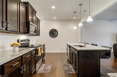Alternate view of the kitchen.  There is tons of counterspace and cabinetry for all your cooking needs!  Not the recessed lighting and pendant lights above the island.