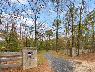 An electric gate and lights welcome you to this pr