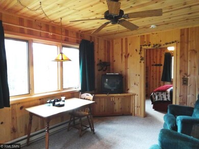Living area inside cabin has knotty pine tongue an
