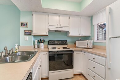 Kitchen with light countertops, white cabinets, a 