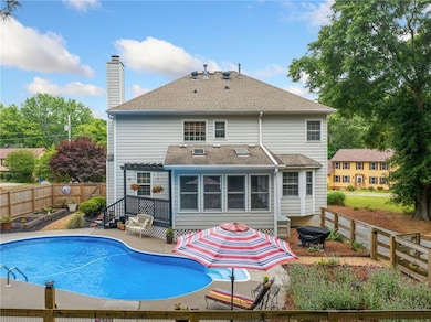 Rear view of property featuring a patio area, a chimney, a fenced backyard, a garden, and roof with shingles
