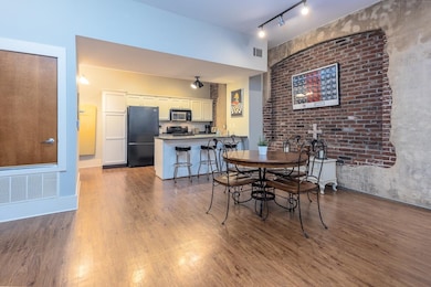 Dining area featuring visible vents, wood finished floors, and rail lighting