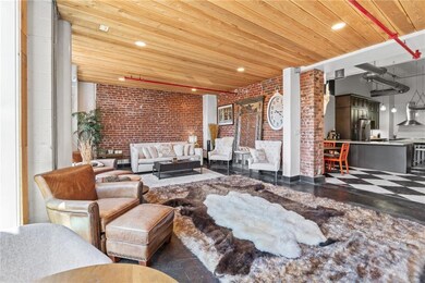 Living room with brick wall, wooden ceiling, and recessed lighting