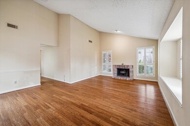 The home feature a combined living and dining space with vaulted ceiling and wood shutters.