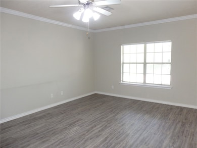 Empty room featuring dark wood-style flooring, cro