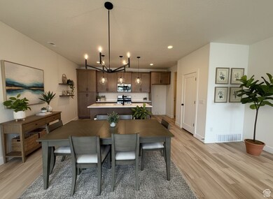 Dining area with light wood-type flooring and recessed lighting