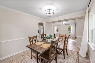 Dining room with an inviting chandelier, light woo