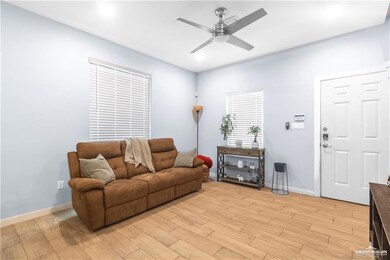 Living area featuring a ceiling fan and light wood finished floors