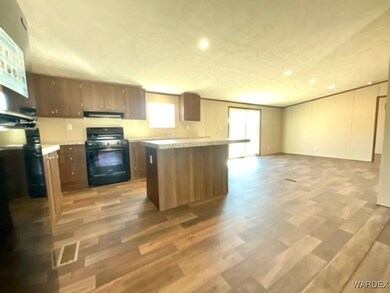 Kitchen with black gas range, exhaust hood, a cent