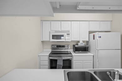 Kitchen with white cabinets, sink, and stainless s