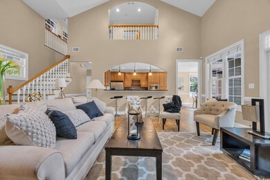 Living room featuring high vaulted ceiling, plenty of natural light, stairway, light wood finished floors, and baseboards