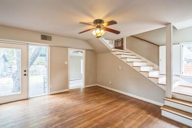 Unfurnished living room with a ceiling fan, stair