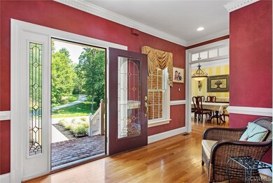 Foyer with wood floors and crown/chair moldings.