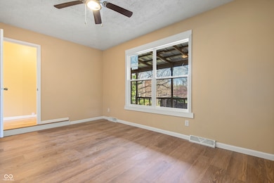spare room with visible vents, baseboards, and wood finished floors