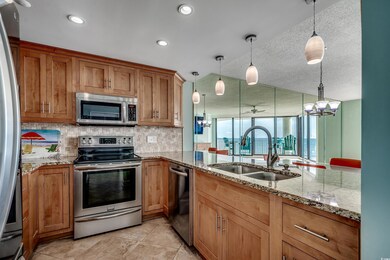 Kitchen featuring stainless steel appliances, a sink, a chandelier, backsplash, and pendant lighting