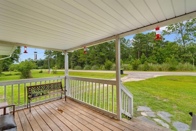 Wooden terrace with a yard and view of wooded area