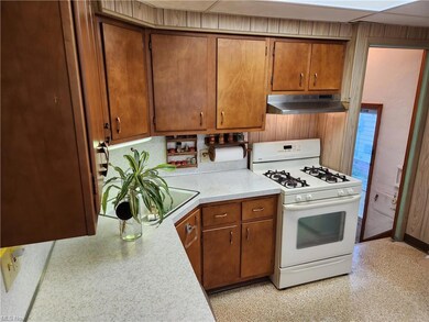 Kitchen featuring white gas stove and countertops 