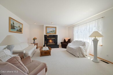 Formal living room with gas fireplace and lots of natural lighting.